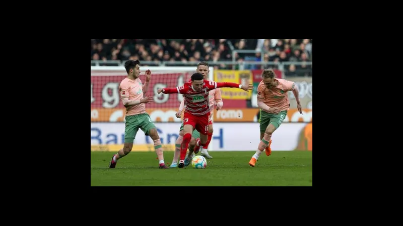 Cầu thủ Augsburg dùng kỹ thuật cá nhân vượt qua hậu vệ Werder Bremen