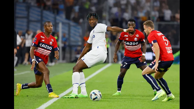 Cầu thủ của Lille chạy nhanh với bóng trước sự truy đuổi của cầu thủ Marseille.